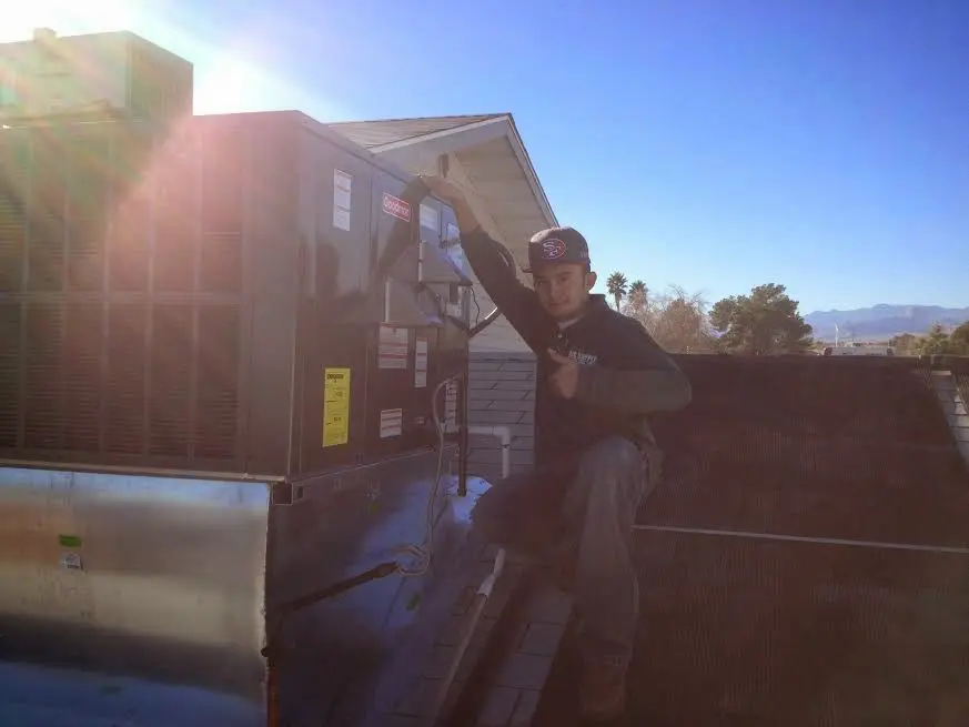 HVAC technician performing Air Duct Cleaning on a rooftop unit in Sawmills